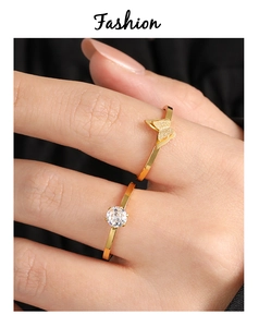 Detalle del anillo de mariposa dorada y anillo clásico de circón en la mano de modelo