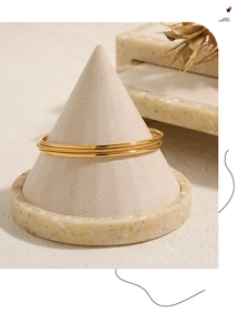 Detail of minimalist gold titanium steel bangles with polished and frosted finishes