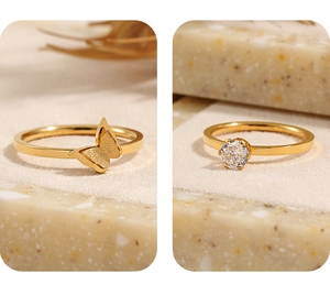 Detalle de anillo de mariposa dorada mate y anillo solitario clásico con circón brillante