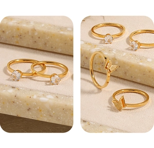 Primer plano de anillos de mariposa dorados y anillos de circón sobre bases de piedra