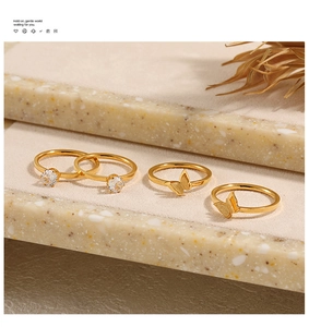 Vista detallada del juego de 4 anillos de oro con motivos de mariposa y circonitas
