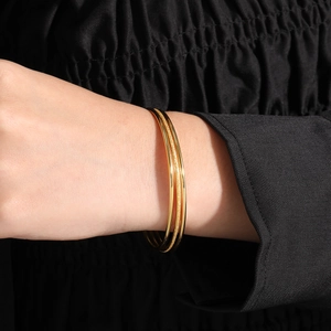 Three-piece gold titanium steel stacking bracelet set with polished and matte finish