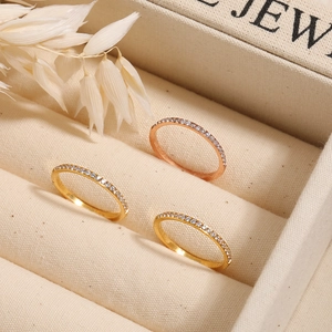 Drei zierliche Ringe in Gold und Roségold mit Zirkonia-Steinen in einer Schmuckschatulle