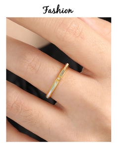 Detail van gouden titanium ring met parelmoer inleg en een kleine centrale diamant