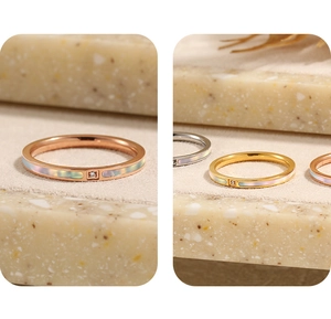 Macro detail van slanke vergulde ring met parelmoer inleg en een enkele kleine zirkoon