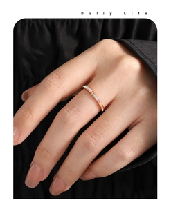 Detail van een roségouden titanium ring met parelmoer inleg en een kleine diamant centraal