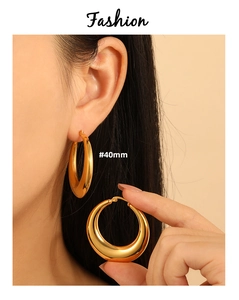 Detailed view of 40mm minimalist gold hoop earrings with a polished mirror finish on model