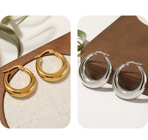 Detailed view of polished gold and silver thick crescent hoop earrings with clasp closure