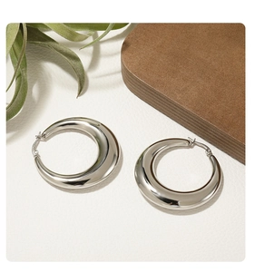 Detailed view of silver thick hoop earrings with a high-polish mirror finish and smooth texture