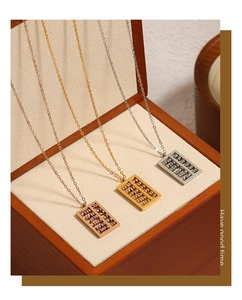 Detailed view of abacus pendants in gold, silver and rose gold finishes on wood