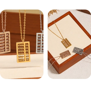 Close-up of three-tone abacus pendants in gold, silver, and rose gold with moving beads