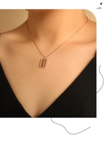 Macro shot of rose gold abacus pendant on a fine O-chain necklace on a female model
