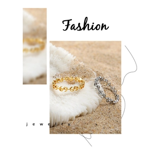 Détail de bagues signe dollar or et argent dans un décor de plage avec des coraux