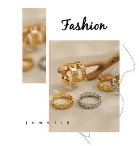 Detailed close-up of gold and silver cuban link chain rings on a natural wood branch