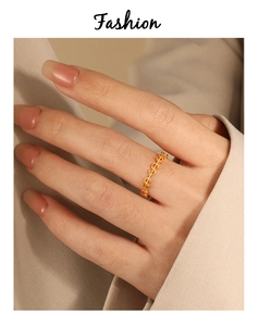 Gros plan d'une bague dollar dorée minimaliste portée au doigt avec un style chic