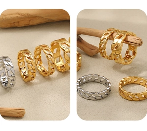 Detailed macro view of gold and silver Cuban link rings with engraved CD logo detail