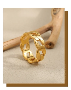 Detailed close-up of golden Cuban link chain ring against a natural stone background