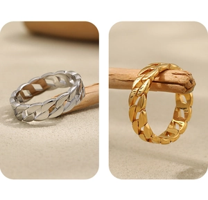 Detailed view of polished gold and silver cuban link rings on wooden display