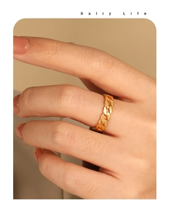 Polished gold cuban link chain ring displayed on hand with warm aesthetic lighting