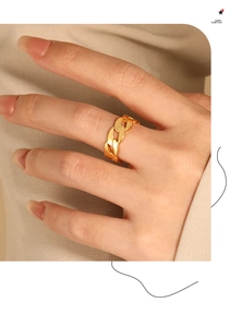 Close-up of a high-polished golden Cuban chain ring worn on a model's index finger