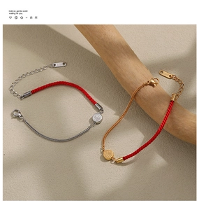 Macro detail of Chinese Fu character pendant on red woven bracelet with 18KGP metal