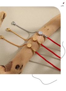 Detailed close-up of lucky red cord bracelets with Fu character charms on wooden stand
