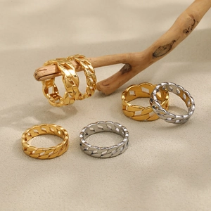 Cuban link chain rings in gold and silver finish on a natural wood display stand