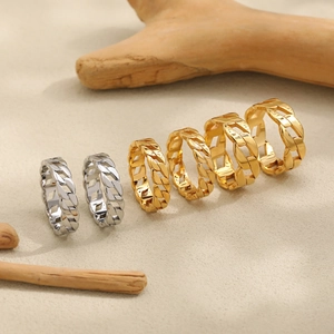 Cuban link chain rings in gold and silver finish on a natural textured background