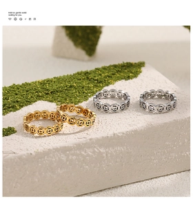 Detail view of Chinese coin rings in gold and silver finish on elegant stone tray