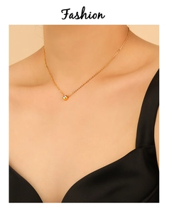 Close-up of minimalist PVD gold-plated titanium necklace with a single zircon pendant