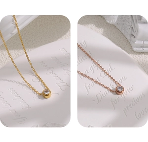 Detail view of minimalist gold and rose gold zircon necklaces on decorative white cards