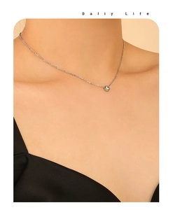 Close-up of minimalist silver zircon necklace with round solitaire pendant on model
