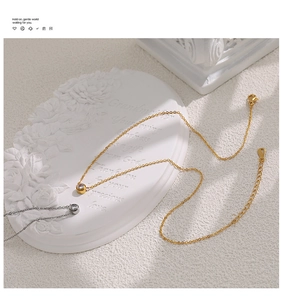Detailed view of gold and silver zircon pendant necklaces on an elegant white display tray