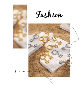 Detail of star-shaped hoop earrings with colorful zircon and 24K gold plated finish