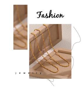 Macro view of a gold oval bead chain necklace with polished 18K PVD finish detail
