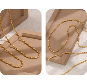 Macro detail of gold PVD plated stainless steel bead chain with oval bamboo link texture