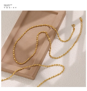 Detail of gold PVD plated stainless steel beaded chain with lobster clasp and tag