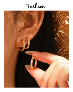 Détail de boucles d'oreilles en acier doré PVD avec zircons cubiques blancs étincelants