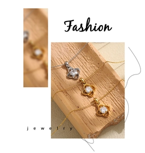 Detailed macro view of gold and silver clover pendants featuring central zircon settings