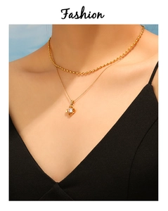 Close-up of double layered gold clover necklace with sparkling zircon on a model