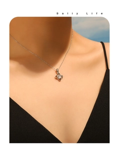 Close-up of sparkling zircon four-leaf clover pendant on fine silver chain necklace