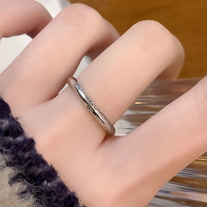 Vue macro d'une bague tordue argentée avec de petits cristaux et un design ondulé élégant