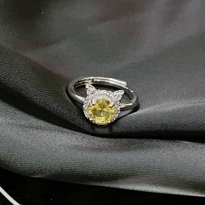 Detalle de anillo de plata con forma de gato, piedra amarilla y circonitas blancas