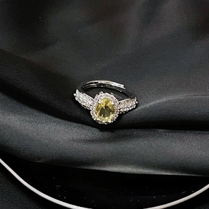 Detalle de anillo ajustable de plata con gema amarilla ovalada y pavé de circonitas