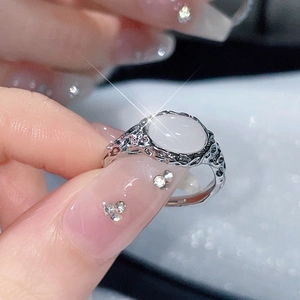 Detail eines silbernen strukturierten Rings mit ovalem Mondstein an einer Hand
