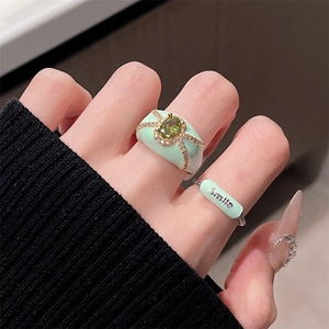 Mint green enamel two-piece ring set with oval gemstone and Smile engraving on hand
