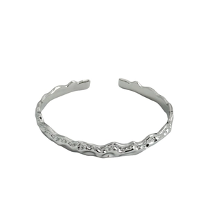 Bracciale rigido aperto in argento minimalista con finitura irregolare in lava fusa