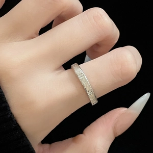 Minimalist brushed silver ring with round cubic zirconia stones on textured metal band