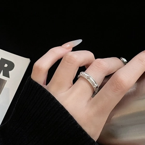 Detailed close-up of a silver ring with star engraving and beaded edges on a finger