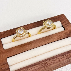 Elegante goldene Drehringe mit quadratischem und rundem Zirkon auf Samt-Holzbox